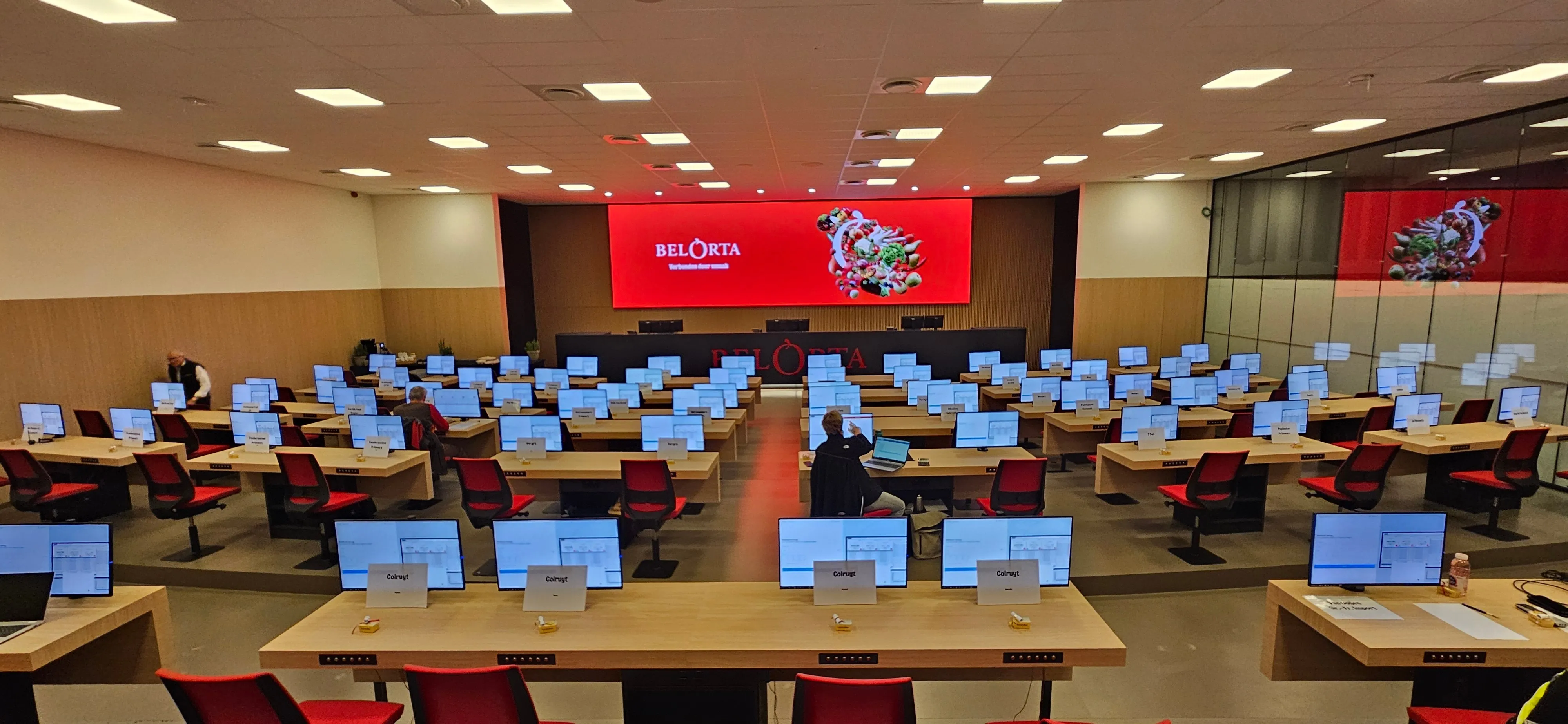 BelOrta auction hall with rows of bench computers showing the veilmodule application