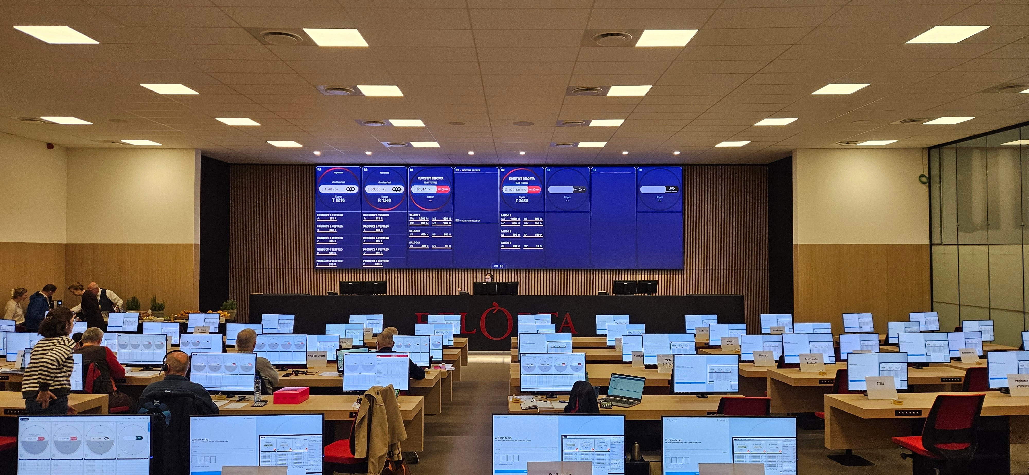 BelOrta auction hall with bench computers and BelOrta branding on the main screen